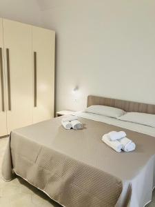 a bedroom with a bed with towels on it at Maiolica in Trapani