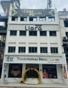 a large white building with a sign on it at Hotel Liora in Rajkot