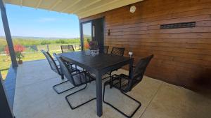 a black table and chairs on a patio at Vila Duplex in Lipovica +13 photos