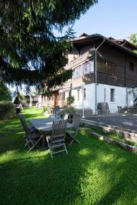a table and chairs in front of a house at Le Bois-Gentil in Gryon