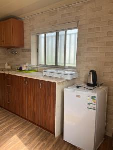 a kitchen with a white refrigerator and a window at Batroun Souq, Perfect location, 1 Bedroom in Batroûn +7 photos