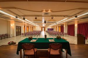 a large banquet hall with a green table and chairs at VOI Florio Resort in Cinisi +29 photos