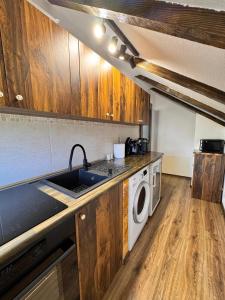 a kitchen with a sink and a washing machine at Voila House in Voila