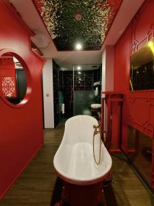 a bathroom with a white tub and red walls at Min Boutique Hotel in Hà Ðông +65 photos