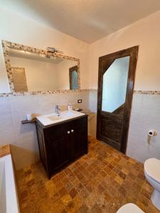 a bathroom with a sink and a toilet and a mirror at Voila House in Voila