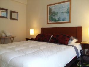 a large white bed in a room with two lamps at Quinta Vergara Montaña in Viña del Mar