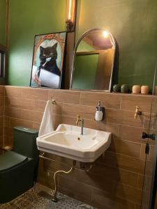 a bathroom with a sink and a cat picture on the wall at Lane 82 Homestay in Chiayi City +29 photos