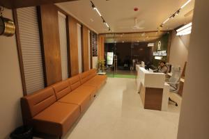 a lobby with a couch and a person sitting in a chair at Balaji Hotel in Somnath