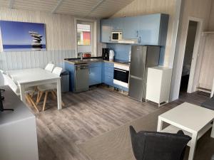 a kitchen with blue cabinets and a table and chairs at Strandhaus Freibeuterweg 24 in Priwall