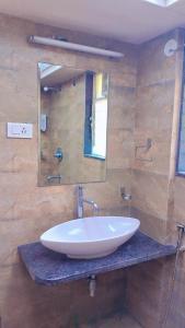 a bathroom with a white sink and a mirror at Tejas Grand villa baner in Pune +23 photos