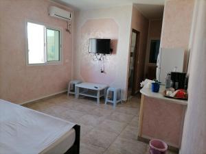 a room with a bed and a kitchen with a table at Beach lodge in Chebba