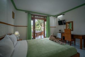 a bedroom with a bed with a stuffed animal on it at Argasoka Bungalows in Ubud