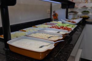 a buffet line with trays of food on a counter at New Wave Hotel in Batumi