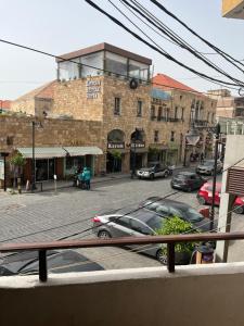 a city street with cars parked in front of a building at Batroun Souq, Perfect location, 1 Bedroom in Batroûn