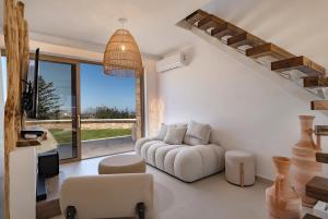 a living room with a couch and a chair at Sunny Villa-Earthen Stone Gem by etouri in Margarítai