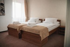 two beds in a hotel room with towels on them at Penzión Hoffer in Nitra +40 photos