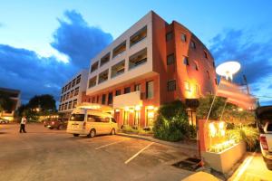 ein Gebäude, vor dem ein weißer Lieferwagen parkte in der Unterkunft โรงแรมพิณ in Lampang