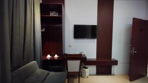 a living room with a couch and a tv at Selah Hotel Dipolog in Dipolog