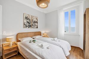 two beds in a white bedroom with a window at Rooms in Villa Agra in Agra