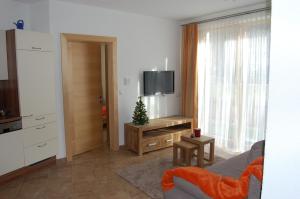 a living room with a television and a christmas tree at Apart Patscheider in Ried im Oberinntal