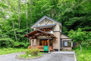 a house in the woods with a driveway at BASE CAMP Kitakaruizawa in Naganohara