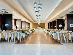 a large banquet hall with white tables and chairs at Hotel Atrium in Târgu Secuiesc +50 photos