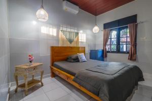 a bedroom with a bed and a table and two lights at Komala Indah 2 in Badung