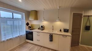 a kitchen with white cabinets and a sink and a window at Kose apartment in Kose