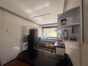 a kitchen with a black refrigerator and a sink at Ahfash Homes in Mombasa