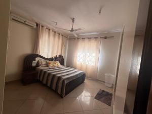 a bedroom with a bed and a window with curtains at Ahfash Homes in Mombasa