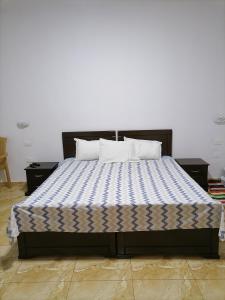 a bed with two pillows on it in a room at Beach lodge in Chebba
