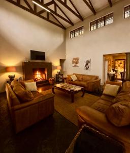 a large living room with couches and a fireplace at Luxury Country Retreat Hot Tub & Farm Views in Dullstroom