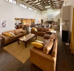 a large living room with couches and a coffee table at Luxury Country Retreat Hot Tub & Farm Views in Dullstroom