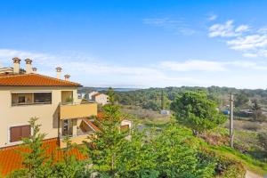 a house on a hill with trees in the foreground at LotusPoolApart in Premantura