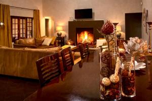 a living room with a couch and a table with a fireplace at Luxury Country Retreat Hot Tub & Farm Views in Dullstroom +68 photos