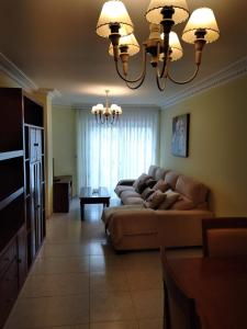 a living room with a couch and a chandelier at Cristel in Puentecesures