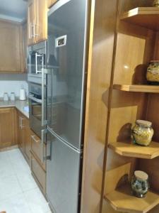 a stainless steel refrigerator in a kitchen with wooden cabinets at Cristel in Puentecesures