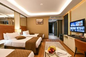 a hotel room with two beds and a flat screen tv at Petra Moon Luxury Hotel in Wadi Musa