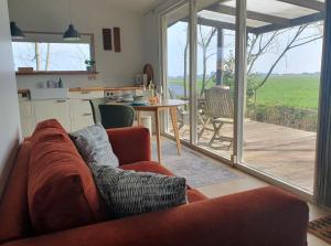 a living room with a couch and a table and a kitchen at Het Groene uitzicht in Bantega