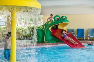 a group of children playing on a water slide in a pool at Sea Crest Oceanfront Resort in Myrtle Beach