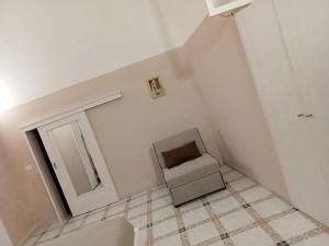 a white room with a chair and a mirror at Residenza Delizia in Gallipoli +3 photos