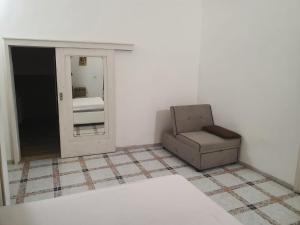 a living room with a chair and a mirror at Residenza Delizia in Gallipoli