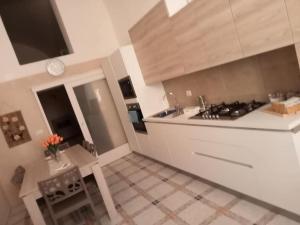 a kitchen with a stove and a sink and a table at Residenza Delizia in Gallipoli
