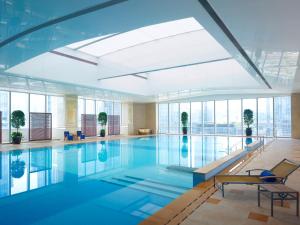 a swimming pool in a building with windows at Futian Shangri-La, Shenzhen in Shenzhen