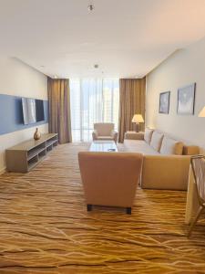 a large living room with a couch and chairs at Plaza Inn Hotel in Doha