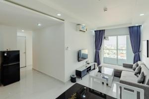 a living room with a couch and a tv at La Living Collection in Ho Chi Minh City