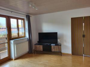 a living room with a flat screen tv on a table at Ferienwohnung Czanderl in Dießen am Ammersee