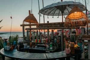 a bar on the beach next to the ocean at ON Hotels Oceanfront Adults Designed in Matalascañas