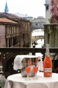 uma garrafa de cerveja sentada numa mesa com dois copos em Hotel Al Ponte Dei Sospiri em Veneza