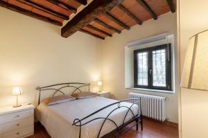 a bedroom with a bed and a window at Felciolina - Medieval Country House in Troghi